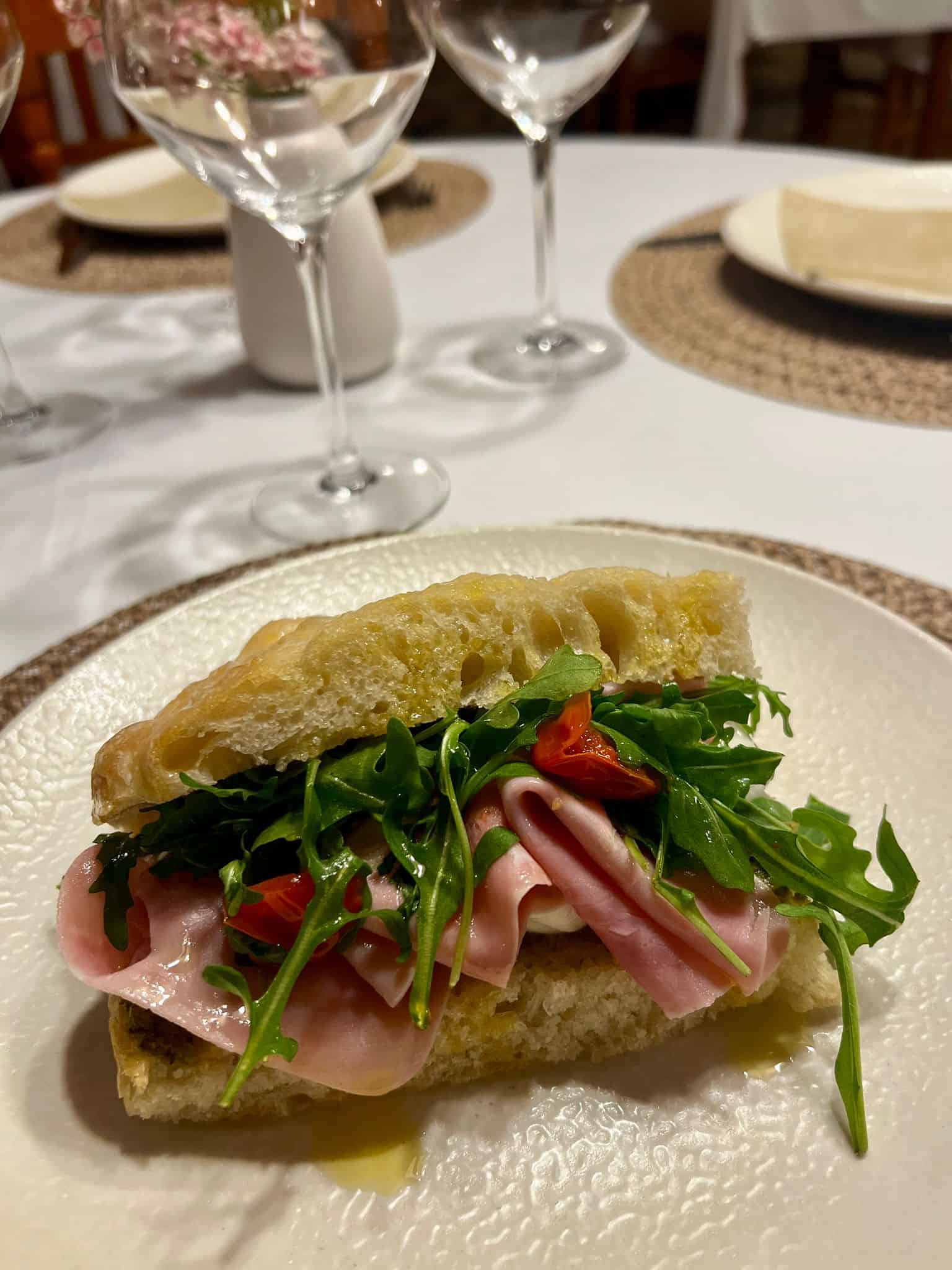 Plato de sándwich con jamón y rúcula en restaurante Posada Santa Rita.